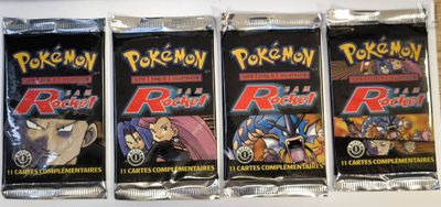 four packs of pokemon trading cards are lined up on a table