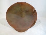 un vase marron posé sur une table blanche