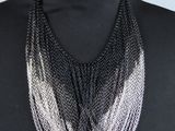 une femme portant un haut noir et un collier à chaîne argentée