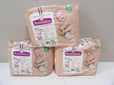 three packs of baby diapers sitting on top of a white table