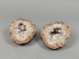 deux morceaux de roche présentant des cristaux blancs et noirs sur une surface grise
