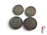 three old chinese coins sitting next to each other on a white surface