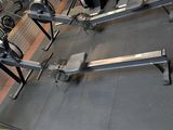 a gym room with a row of machines and a bench
