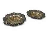 a pair of silver plated dishes on a white background