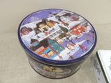 a tin box with a picture of a town on it