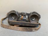 an old pair of binoculars sitting on top of a piece of wood