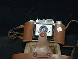 a small camera with a strap around it on a black surface