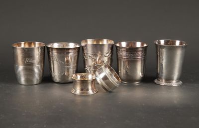 Plusieurs coupes et tasses en argent sont alignées sur une table