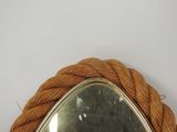 a mirror with a rope around it on the wall