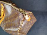 a brown bag with a zipper on it sitting on a blue surface