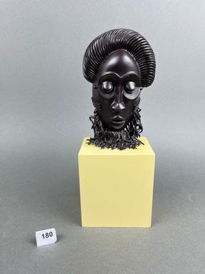 a black sculpture of a ram head on a yellow pedestal
