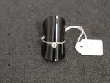 a ring with a diamond on it sitting next to a price tag