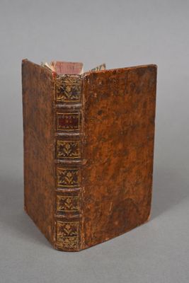 an old book with a brown cover sitting on top of a table