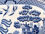 a blue and white plate with birds and flowers on it