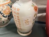 two vases sitting on a table next to each other