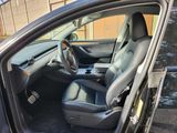 the interior of a car with the door open and the driver ' s seat down