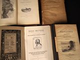 several old books sitting on top of a table next to each other