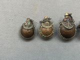 three antique silver and gold lockes with colorful stones on them