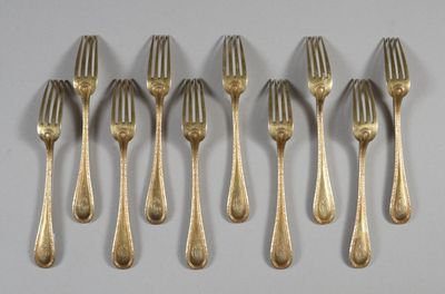 six forks are lined up in a row on a white surface