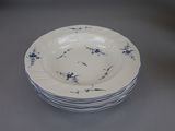 a stack of blue and white plates sitting on a table