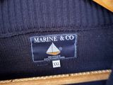 the label on the back of a jacket reads marine and co