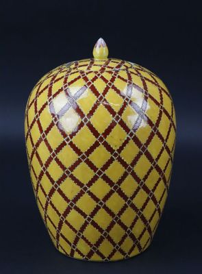 un vase en forme de pomme orné d'un motif rouge et jaune