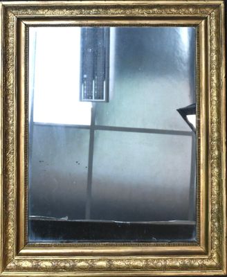 un cadre doré avec un miroir, posé sur une table