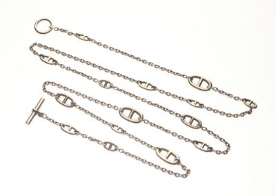 trois bracelets à maillons argentés sur fond blanc