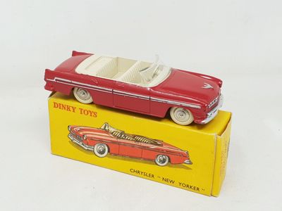 a red toy car sitting on top of a yellow box