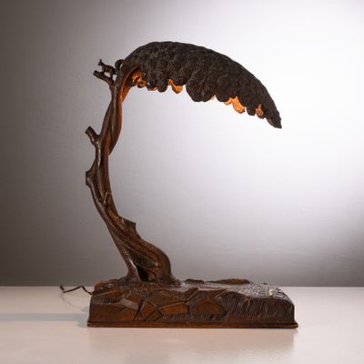 une sculpture en bronze représentant un oiseau perché sur une branche d'arbre