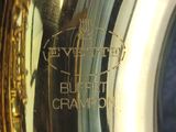 a close up of a saxophone with a person ' s hand holding it