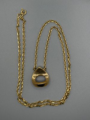 gros plan d'une chaîne en or sur laquelle est fixée une bague