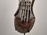 sculpture of a musical instrument on a stand on a white surface
