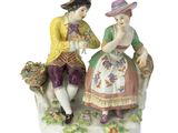 deux figurines d'un homme et d'une femme assis sur un banc
