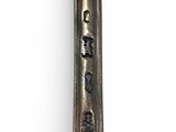 a silver spoon with writing on it sitting on a white surface