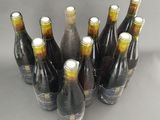 six bottles of wine are lined up in a row on a table