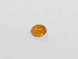 a close up of a yellow sapphire stone on a white surface