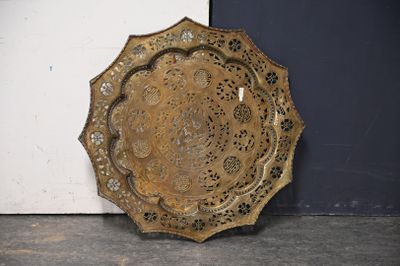 une plaque métallique posée sur le sol, près d'un mur