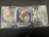 three packs of pokemon trading cards sitting on top of a table