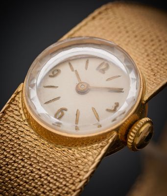 un gros plan d'une montre en or sur fond noir