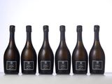 six bottles of champagne lined up in a row on a table