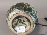 a small vase with a tag on it sitting on a table
