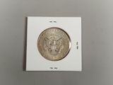 un gros plan d'une pièce de monnaie dans une boîte blanche posée sur une table