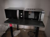 two microwaves that are sitting on a table