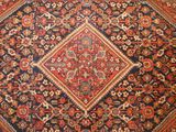 an antique persian rug with a diamond design