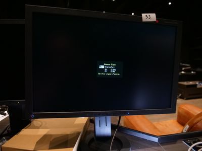 un écran d'ordinateur posé sur un bureau à côté d'un clavier