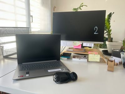 un ordinateur portable posé sur un bureau, à côté d'un écran