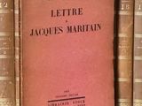 un livre posé sur une étagère, devant une pile de livres