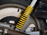 a close up of a motorcycle with a yellow shock absorbr on it