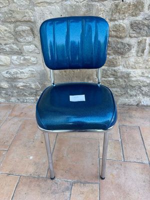 une chaise bleue posée devant un mur de pierre